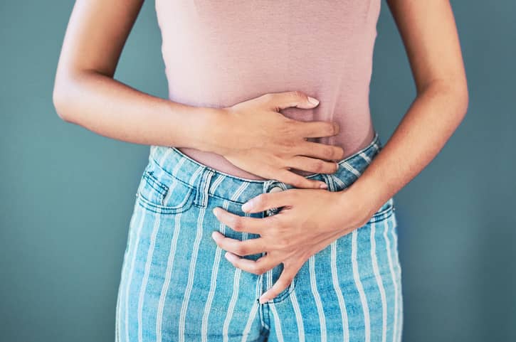 Person with pelvic pain holding their tummy